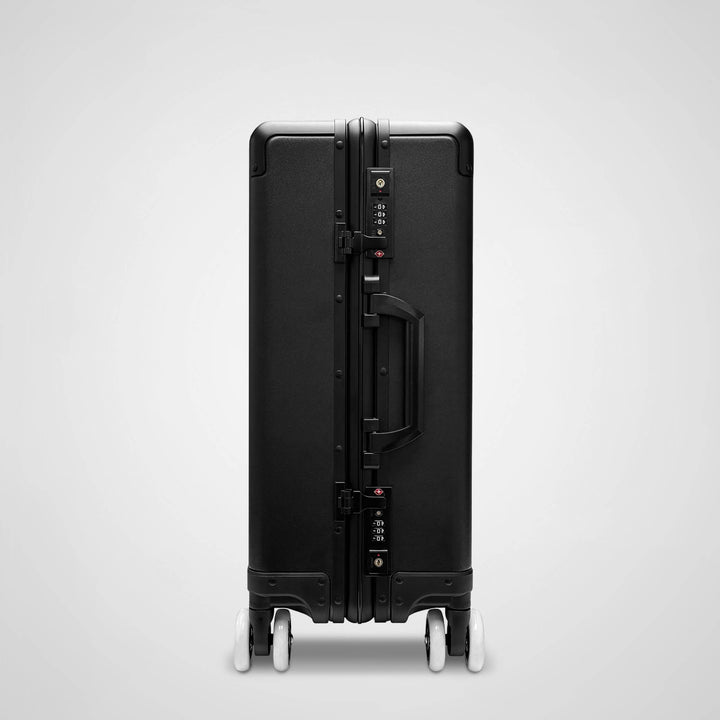 Black suitcase with wheels on a light gray background