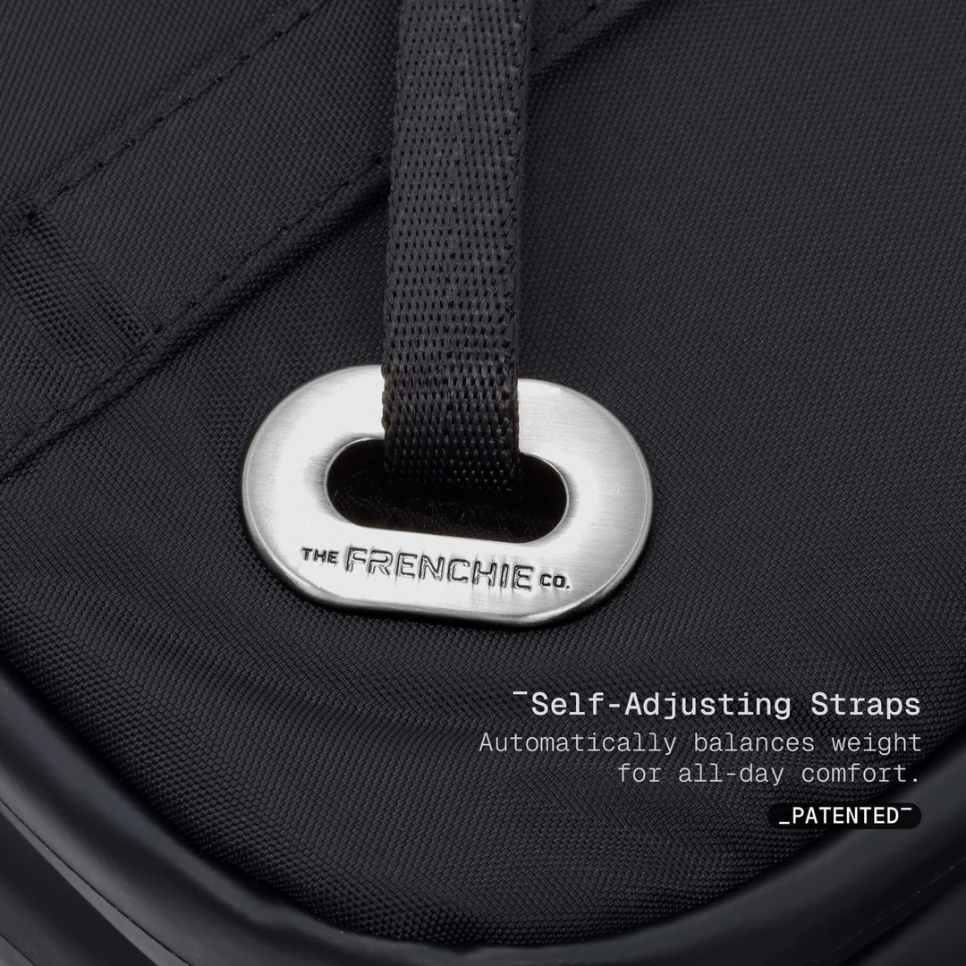 Close-up of a black pet carrier with a self-adjusting strap labeled &