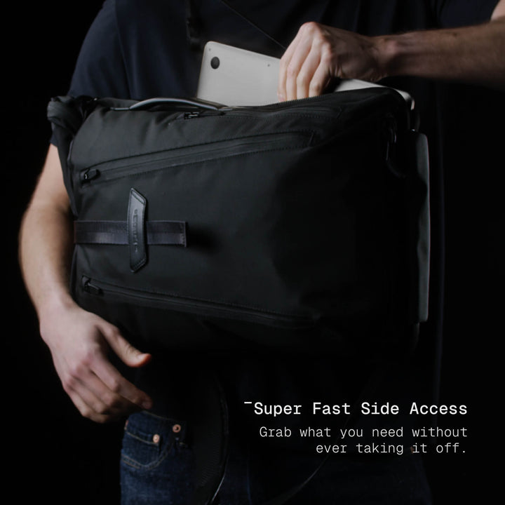 Person holding a black backpack with text &